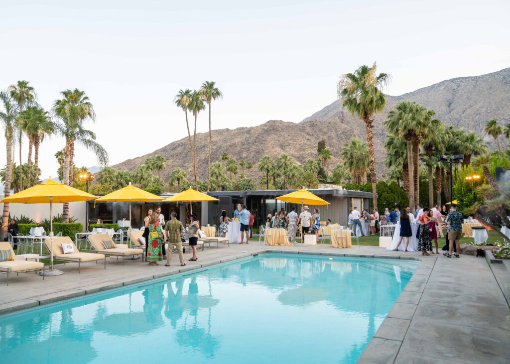 Palm Spring views with Palm Trees and guests enjoying a pool party