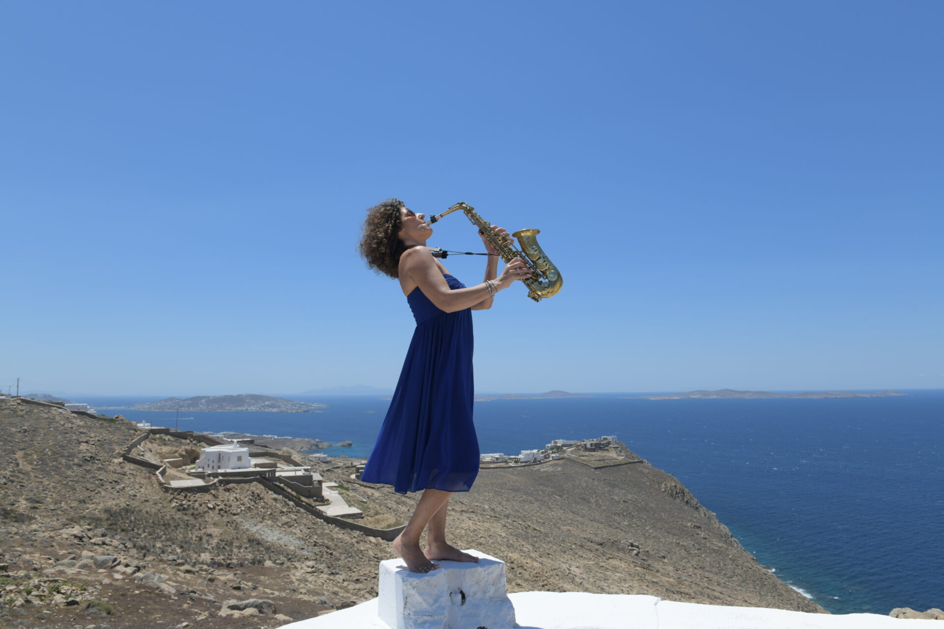 Woman playing the clarinet in a beach setting.