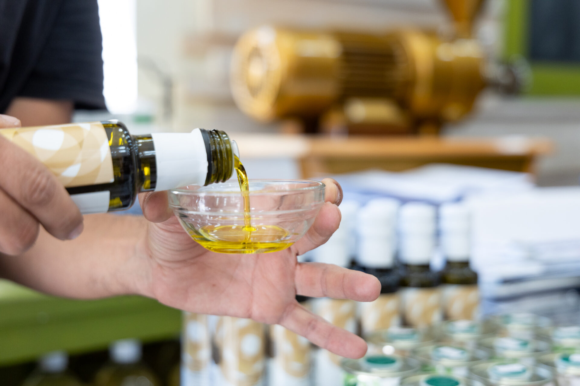 Man pouring olive oil in a glass bowl