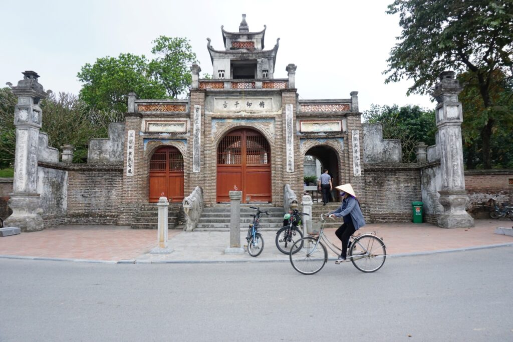Hanoi temple with local ride the bicycle in the front.