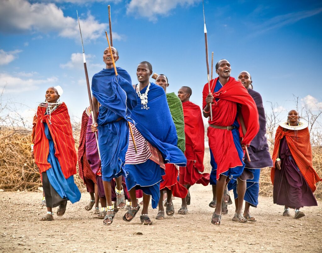 Maasai warriors performing traditional dance in Tanzania, showcasing vibrant cultural heritage, rhythmic movements, and colorful attire.