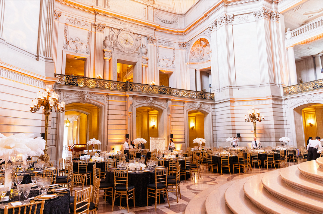 interior of San Francisco City Hall with round tables and feather centerpieces