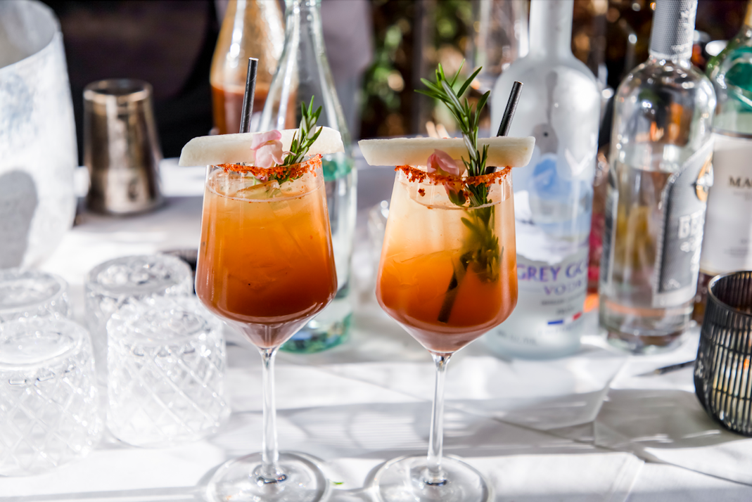 two glasses with red cocktails in them