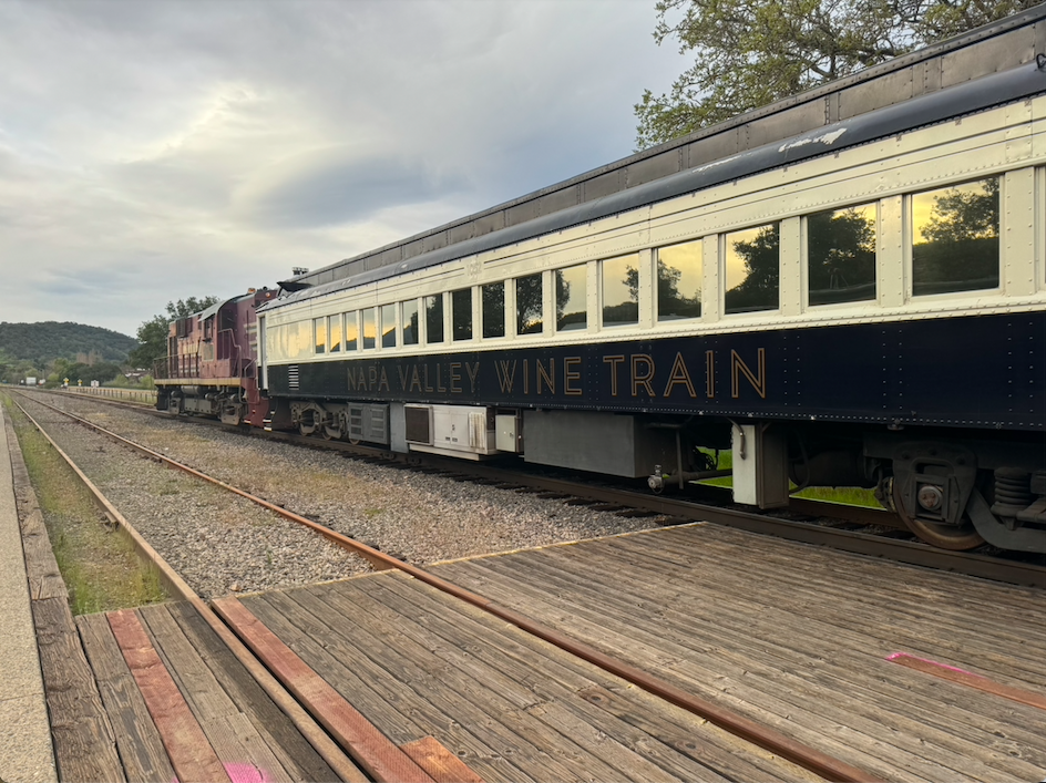 Train cars on tracks that reads Napa Valley Wine Train
