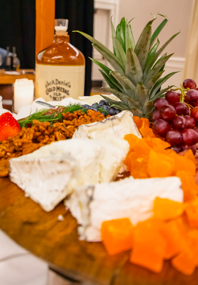 wood tray with cheese and fruit on it