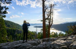 woman taking a photo of Lake Tahoe with her smart phone