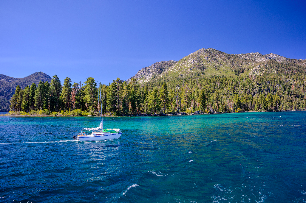 sailboat on Lake Tahoe with mountains in the background.