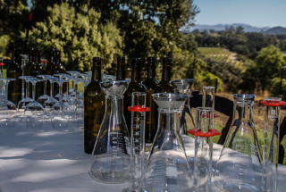 wine bottles and glasses on a white tabelcloth outside