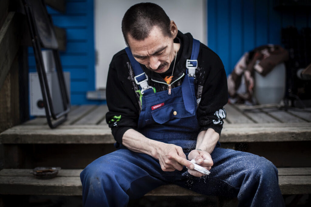 Inuit man sitting on a porch