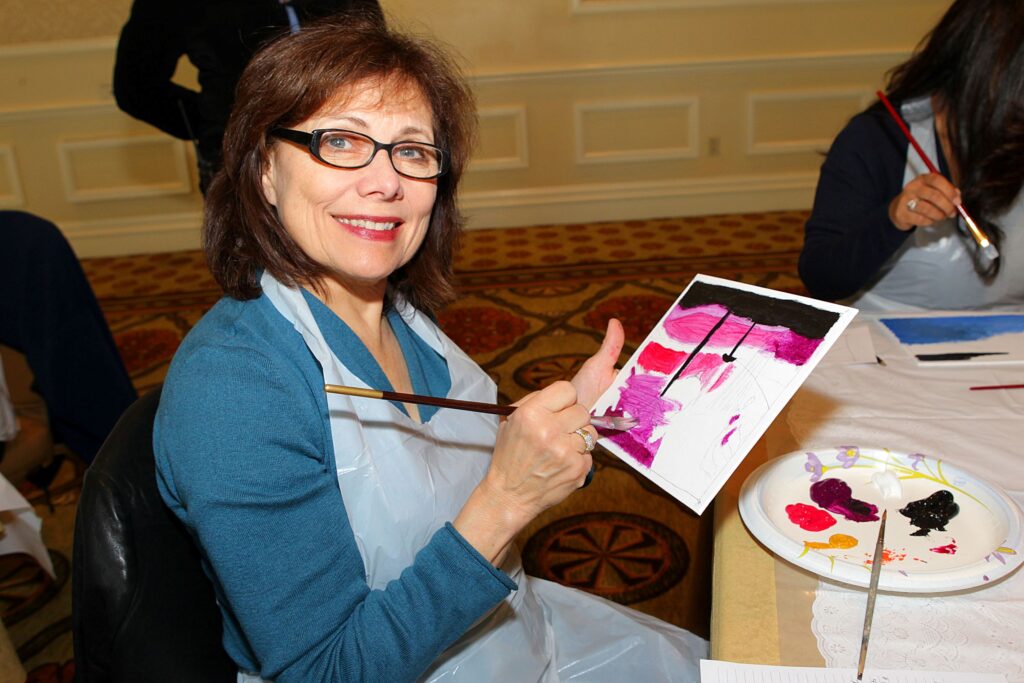 A happy women painting on a canvas