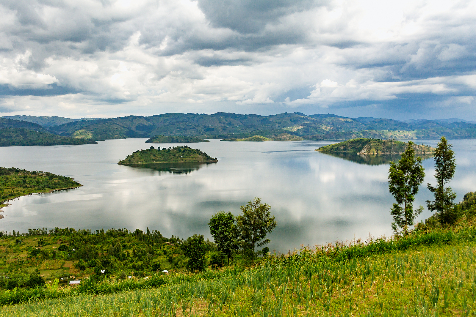 Scenic view of Lake Kivu in Rwanda, with serene waters and lush green hills, —a top destination for relaxation, water activities, and eco-tourism in East Africa.