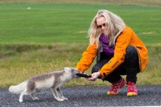 Woman feeding a small animal