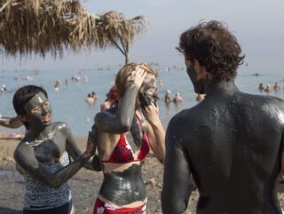People enjoying a Mud treatment in the Dead Sea