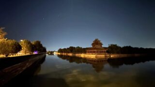 A view of a Beijing building at night from the water