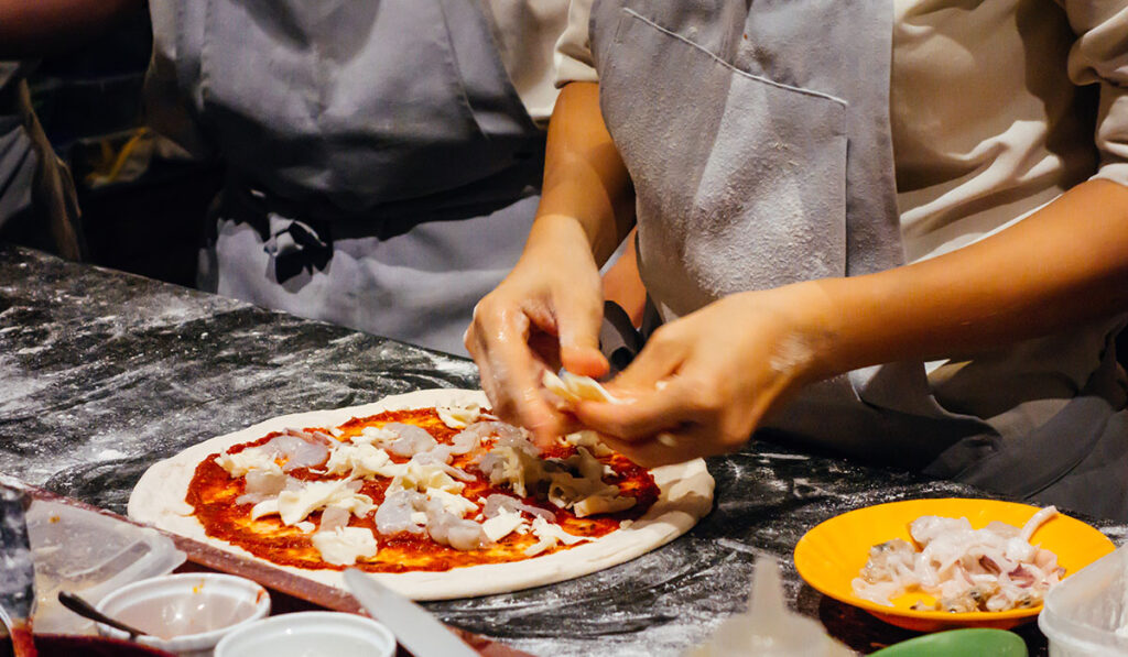 A person making a Neapolitan-style pizza